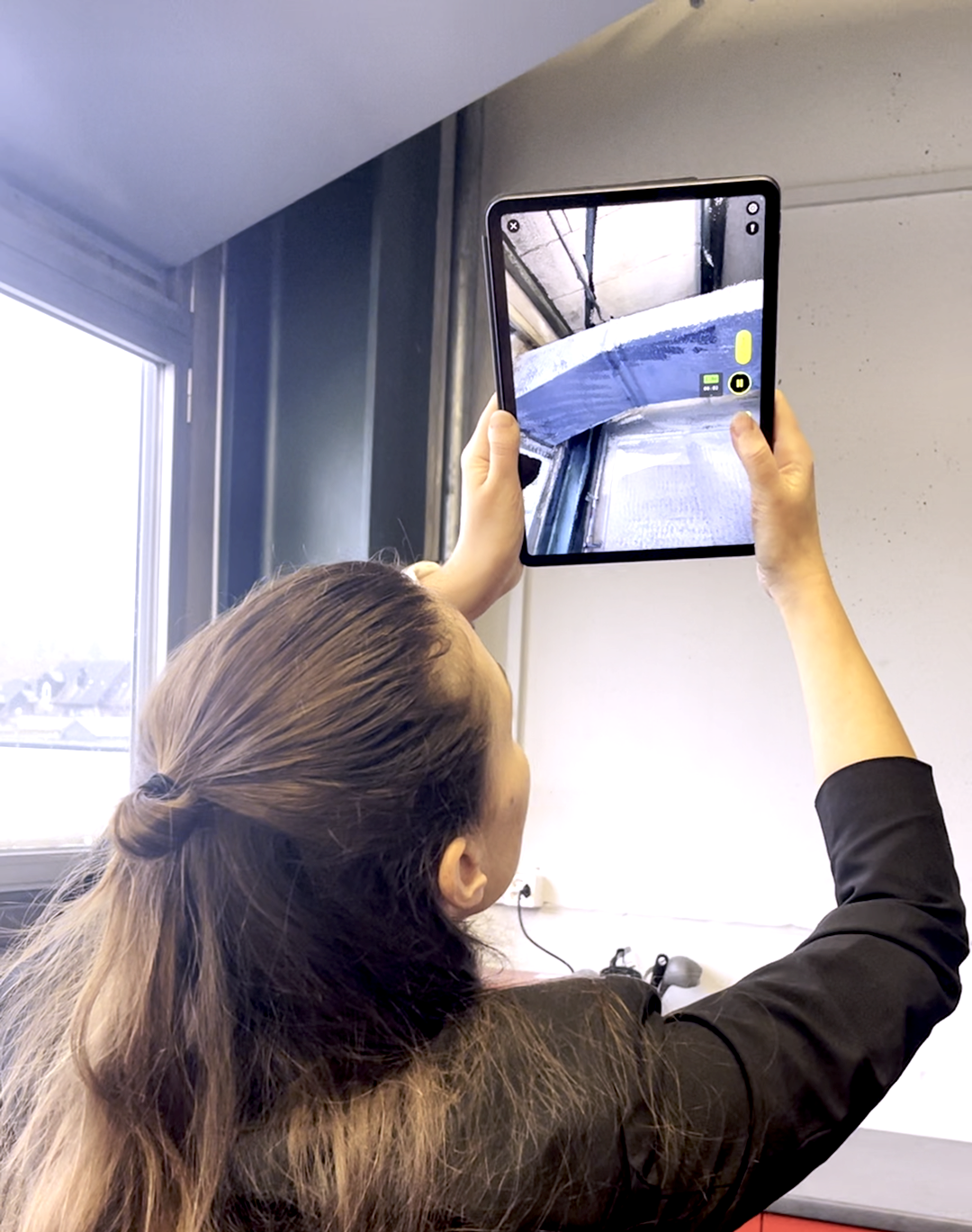 User holding iPad Pro while capturing a 3D scan of interior room with MAVO 3D